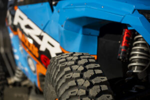 the top of a Maxxis Roxxzilla tire with a powder blue body of a SxS in the back ground.