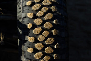 Tight shot of the tread of the Maxxis RAZR XT. A light coating of sand is sticking to each tread block.