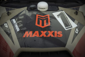 black hood with the MAXXIS logo and M ikon front and center with a bold black number 1 over white background.