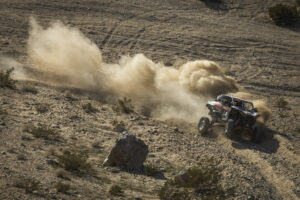 Jeremy McGrath attempting to keep his red and black Kawasaki SxS on at least two wheels.