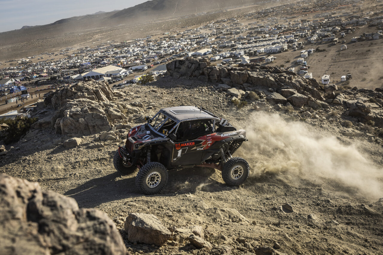 Maxxis athlete Jeremy McGrath cresting a hilltop in his red and black KRX SxS.