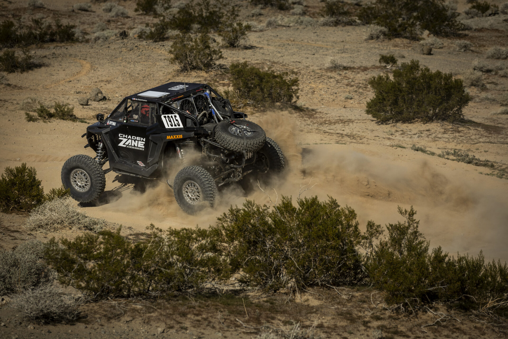 Chaden Minder in his all black SxS racing through the Lucerne Valley on the way to his first OA podium at Desert Challenge.