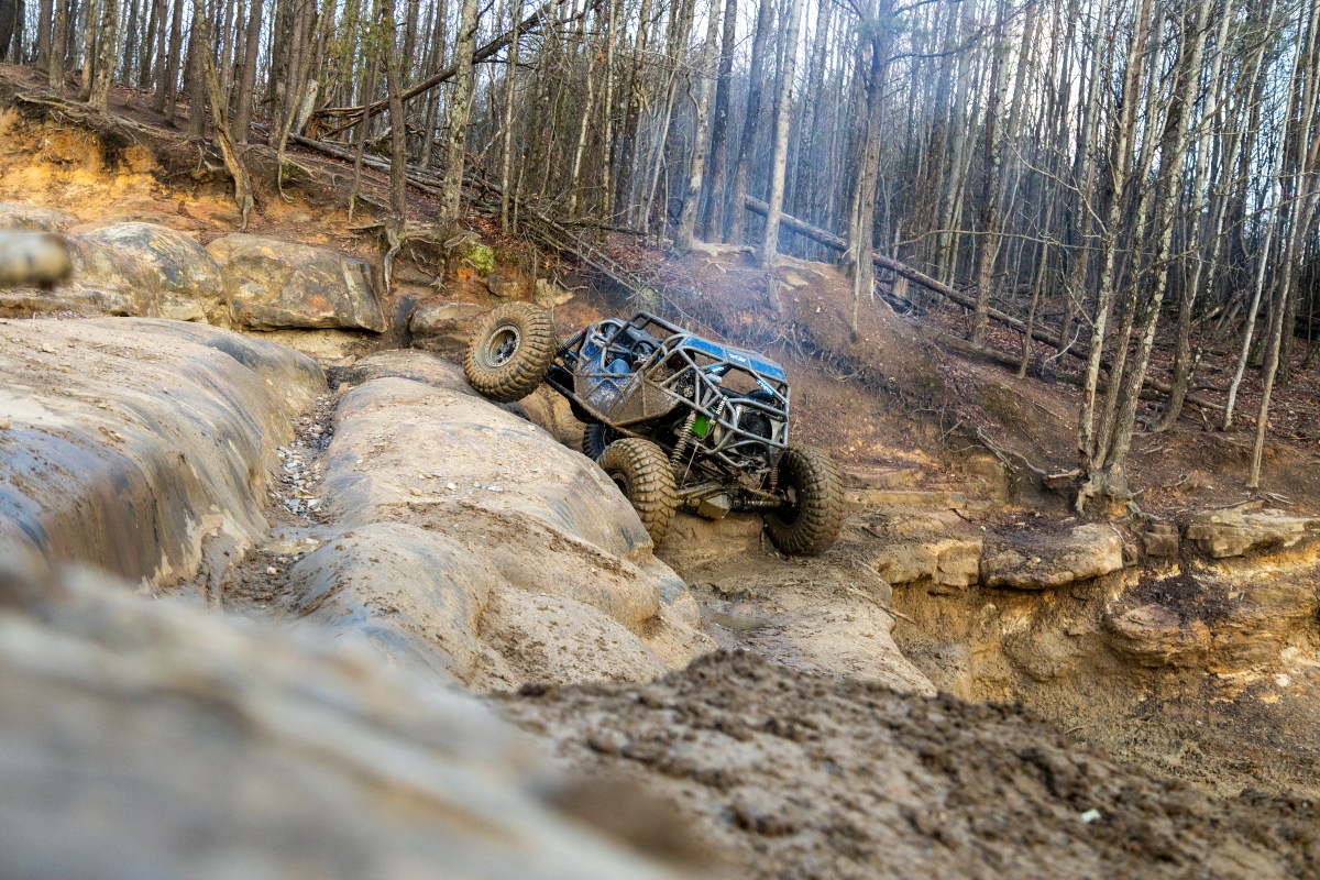 off-road car going up a large rock ledge
