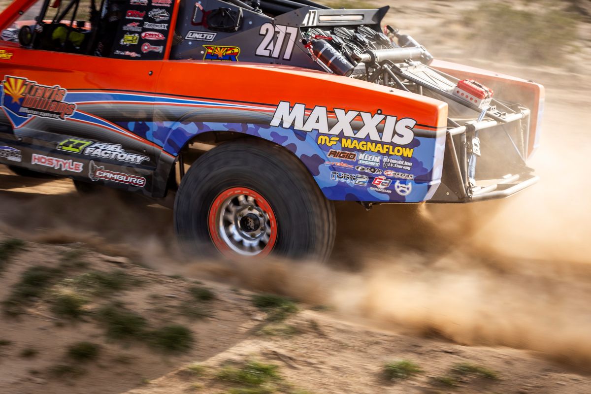Tight-rear-quarter shot of trophy truck with prominent maxxis logo