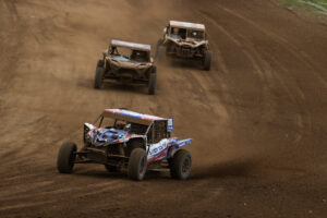 a polaris SxS sprays roost as it turns right heading up hill from a sweeping right hand turn.