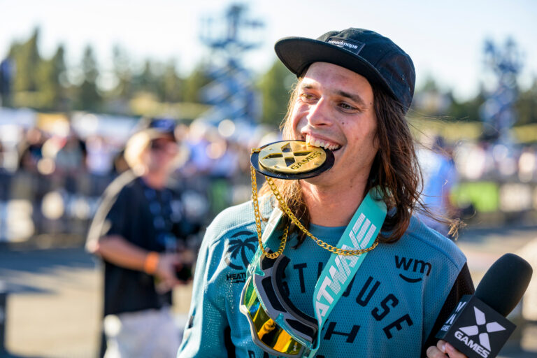 Pat Evans holding a gold X Games medal in his mouth.