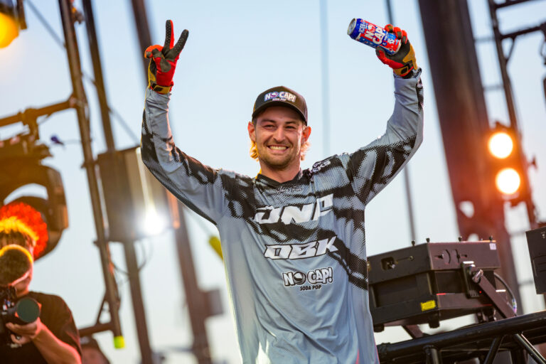 Wyatt holding up a can in his left hand and a v for victory on his right hand while smiling after a third place finish.