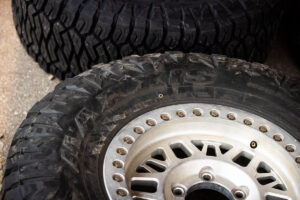 Detailed view of Maxxis off-road tire treads and wheels stacked in the pits.