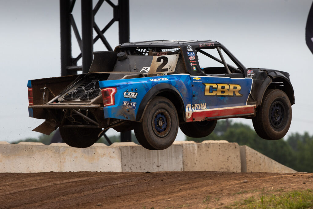 CBR racing truck getting air time on the track. 