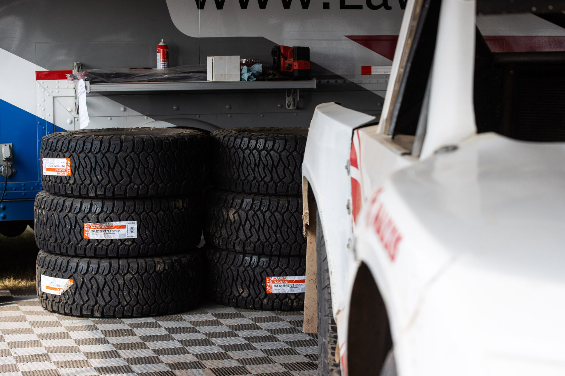Stack of RAZR AT tires, next to a race truck in the pits.