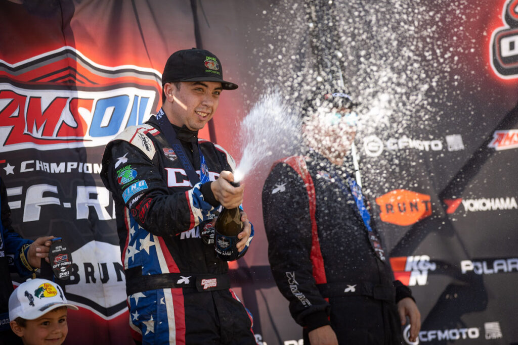 Connor Berry on the Podium popping a champagne bottle