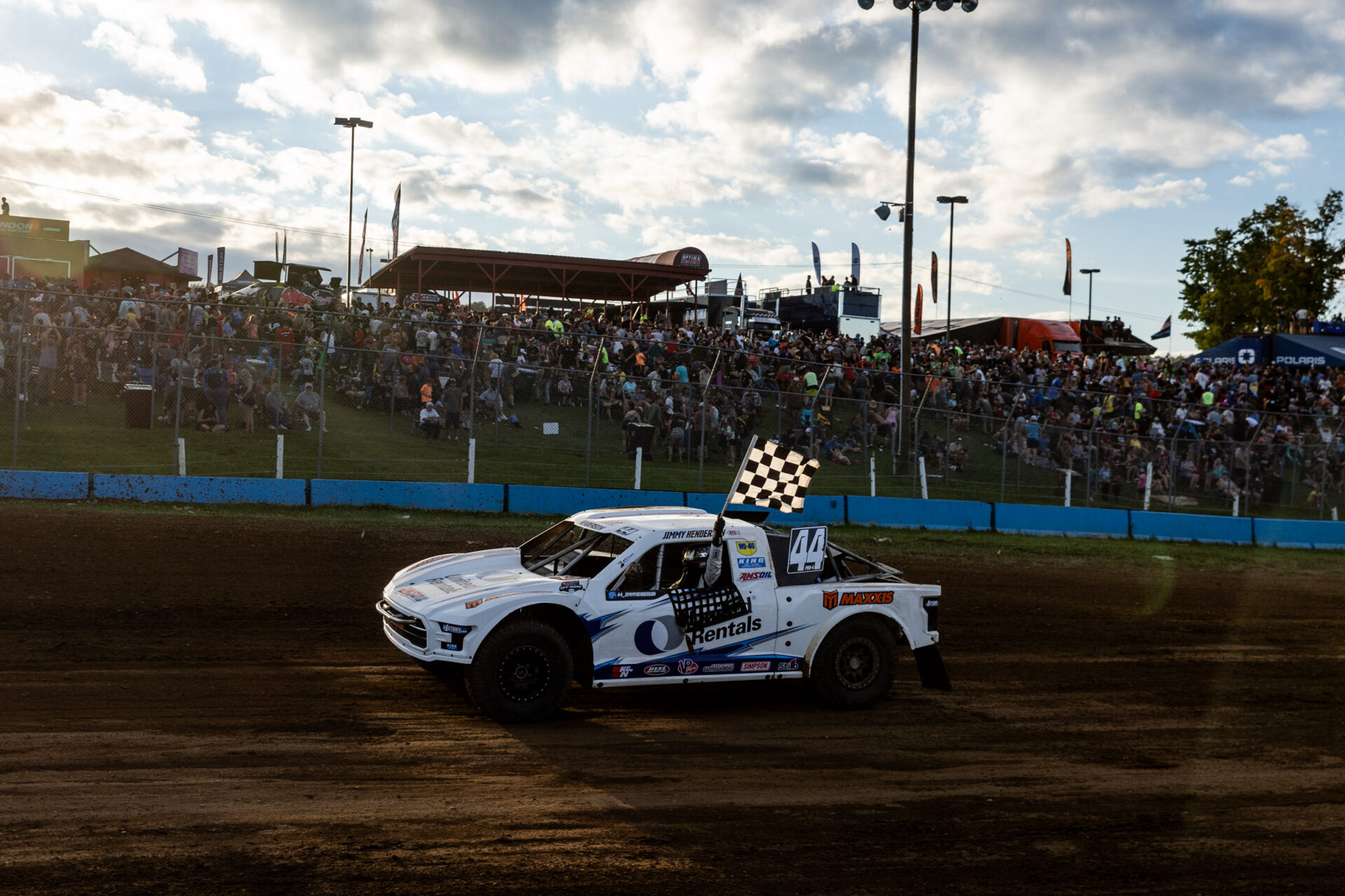 Maxxis athlete on track, with flag