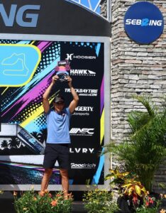 Athlete holding up a trophy on podium