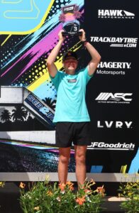 Athlete holding up a trophy on podium